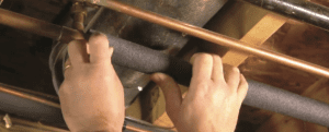 person stalling foam pipe insulation
