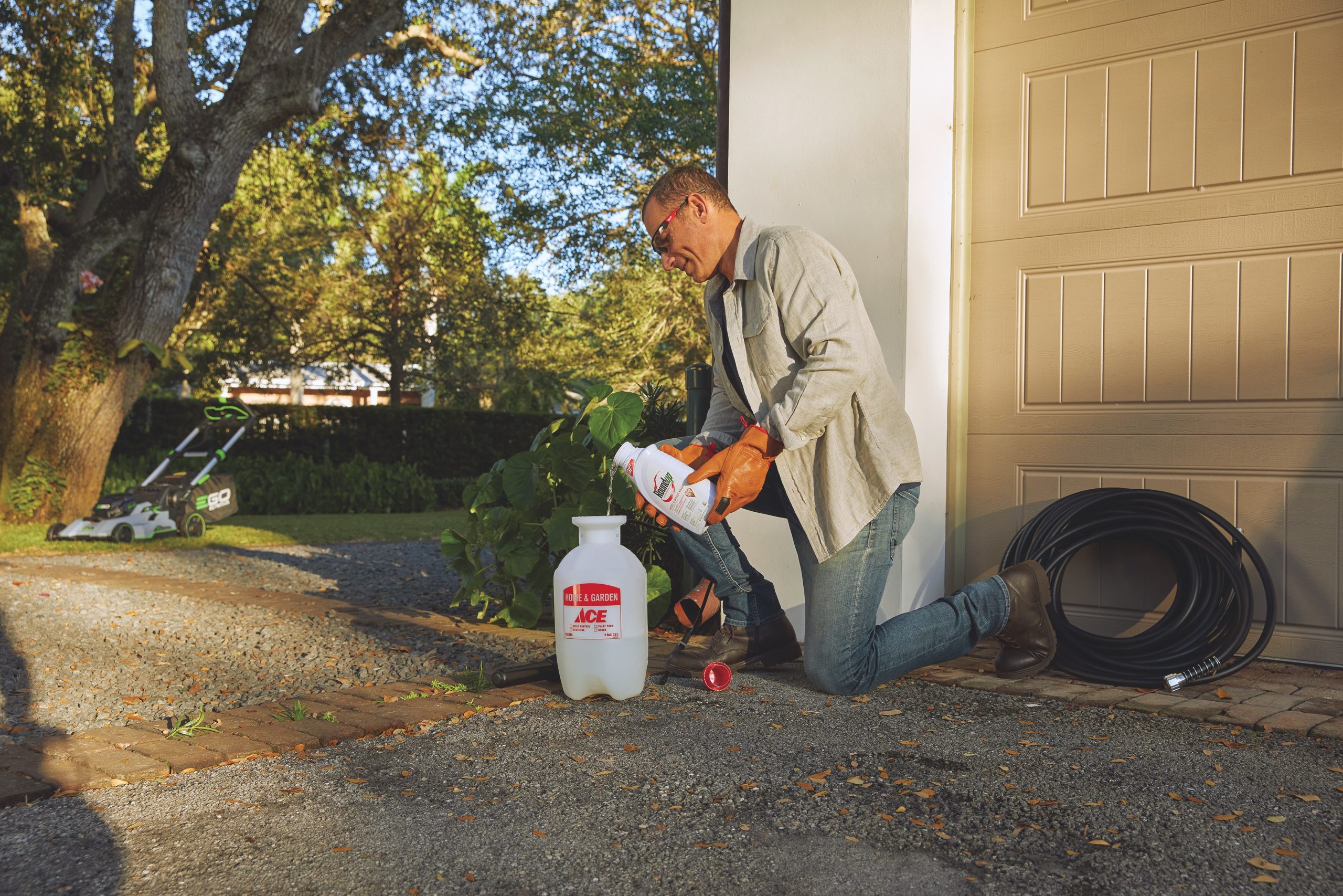 Man pouring weed killer in tank sprayer.